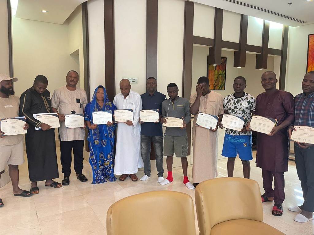 Programme participants standing together holding certificates.