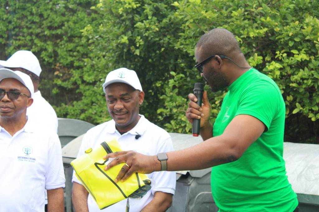 Partners handing over materials during a plastic recovery and community engagement programme.