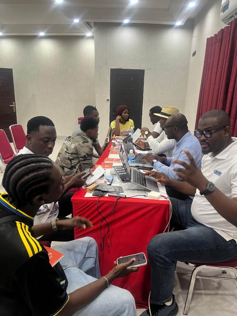 Participants and facilitators around a working table during a training programme.